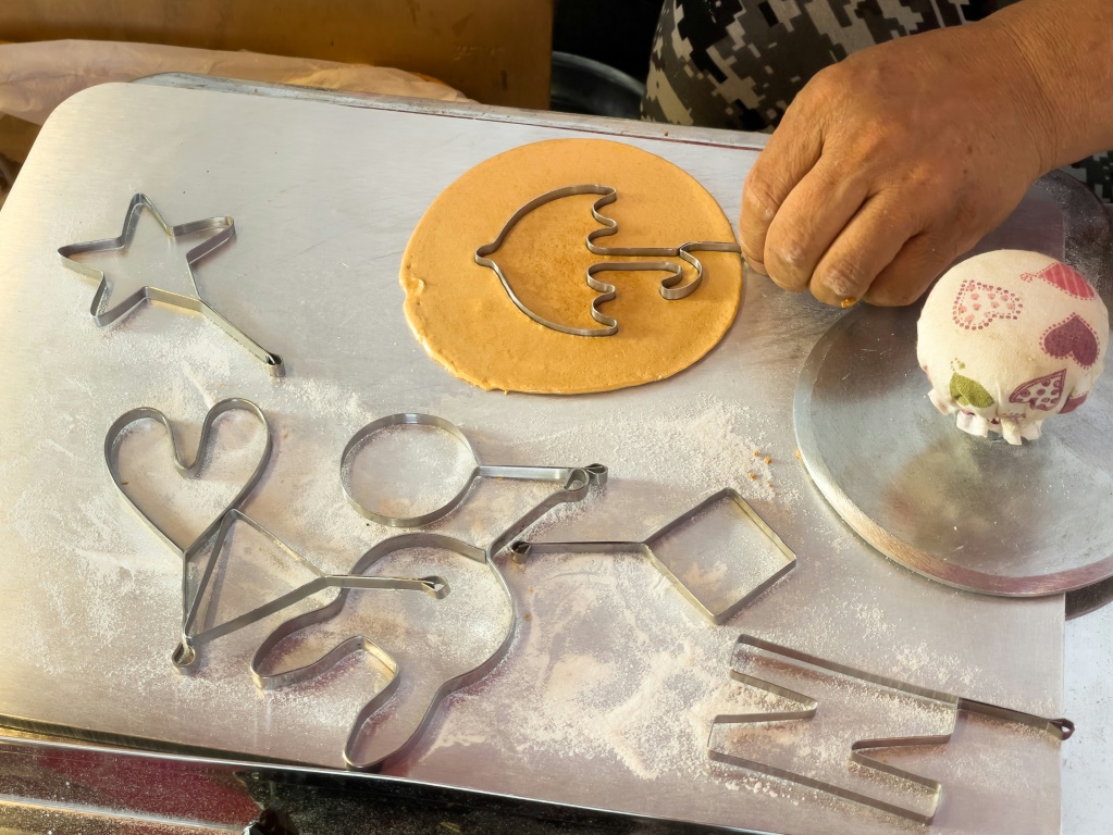 ليم تشانغ جو يقطّع حلوى دالغونا على شكل مظلة في كشكه في سيول في 10 تشرين الأول/أكتوبر 2021(ا ف ب)