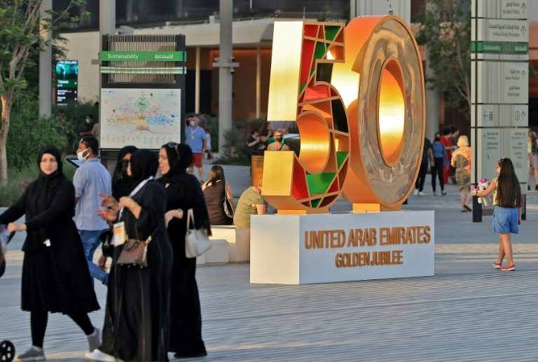 مشهد عام لمعرض إكسبو دبي 2020 في 28 نوفمبر 2021 ويبدو فيه عدد من الزوار ومجسم يحتفي بالذكرى الخمسين لتأسيس دولة الإمارات ( ا ف ب )