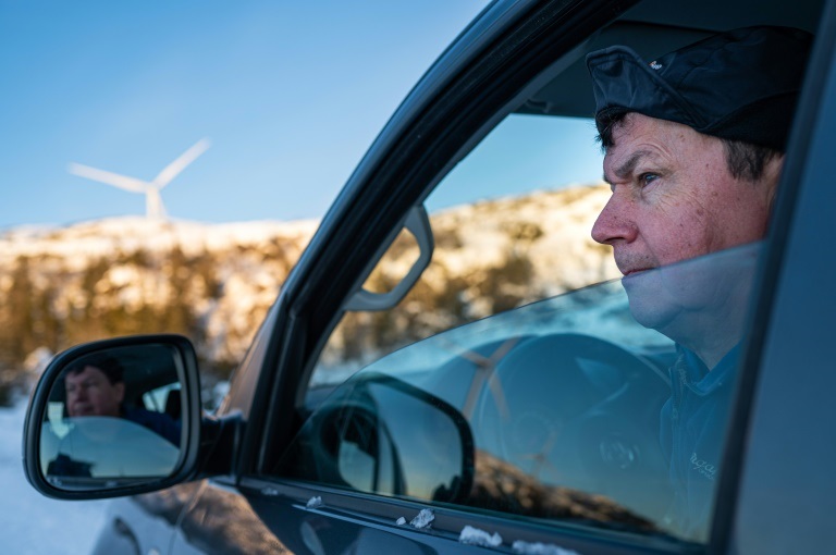 مربي حيوانات الرنة ليف ارنه جوما يدل من سيارته إلى حقل توربينات ستوريا في أفيورد النروجية في 7 كانون الأول/ديسمبر 2021 (ا ف ب)