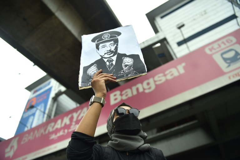 ترفع صورة رئيس الهيئة الماليزية لمكافحة الفسادي عزام باكي خلال تظاهرة للمطالبة باستقالته في كوالالمبور في 22 كانون الثاني/يناير 2022 (ا ف ب)