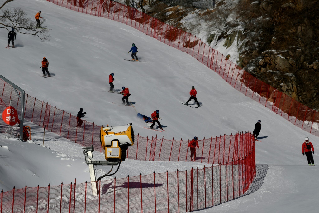 أطباء صينيون يشاركون في عملية إنقاذ وهمية على منحدر مركز يانكينغ للتزلج الألبي ضمن الاستعدادت لاستضافة أولمبياد بكين 2022 في 12 يناير 2022 (ا ف ب)