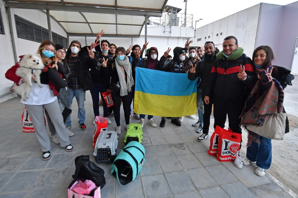 طلاب تونسيون تم اجلاؤهم من أوكرانيا يحملون العلم الأوكراني لدى وصولهم إلى مطار قرطاج في العاصمة التونسية في الأول من آذار/مارس 2022 (أ ف ب)