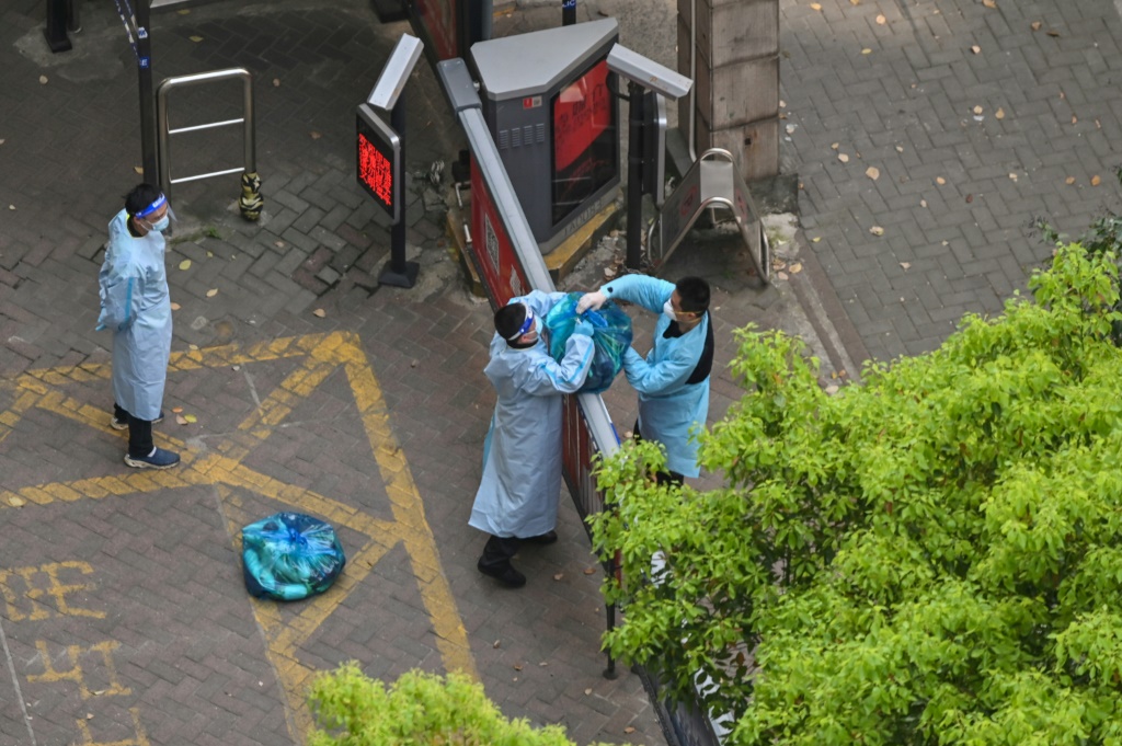 حارس يرتدي ملابس واقية يتسلم بضائع أوصلت الى المبنى خلال العزل في حي جينغان في شنغهاي في 8 نيسان/ابريل 2022.(ا ف ب)