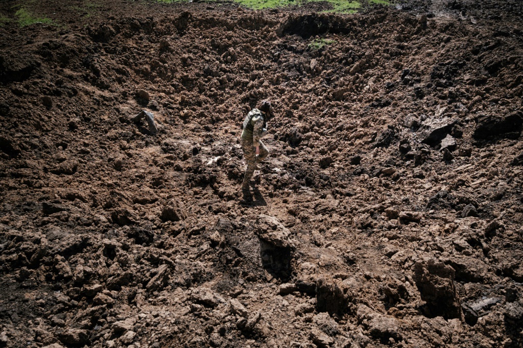 عسكري أوكراني يعاين حفرة خلفها سقوط صاروخ في 25 نيسان/أبريل 2022 في بوهوداروف في شرق أوكرانيا (ا ف  ب)