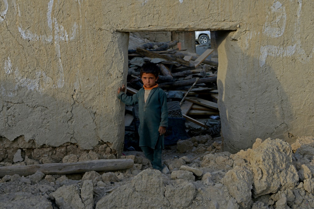 صبي يقف داخل منزل مدمر بعد الزلزال الذي ضرب قرية أختار جان (أ ف ب)