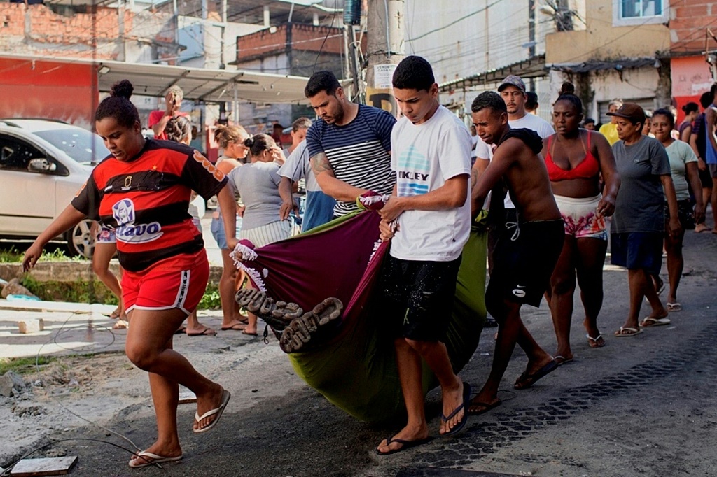 سكان ينقلون جثة رجل قتل خلال عملية للشرطة البرازيلية في "كومبليكسو دو آلامو"، مدينة الصفيح الواقعة في ريو دي جانيرو، في 21 تموز/يوليو 2022. (ا ف ب)