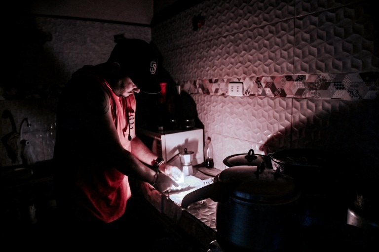 صورة التُقطت في 25 أيار/مايو 2022 تُظهر رجلًا في المطبخ على ضوء الشمعة خلال انقطاع للتيار الكهربائي في هافانا عاصمة كوبا (ا ف ب)