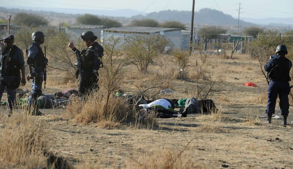 الشرطة أمام جثث المتظاهرين الذين أطلقوا النار عليهم بالقرب من منجم ماريكانا (جنوب إفريقيا) في 16 آب/أغسطس 2012 (ا ف ب)