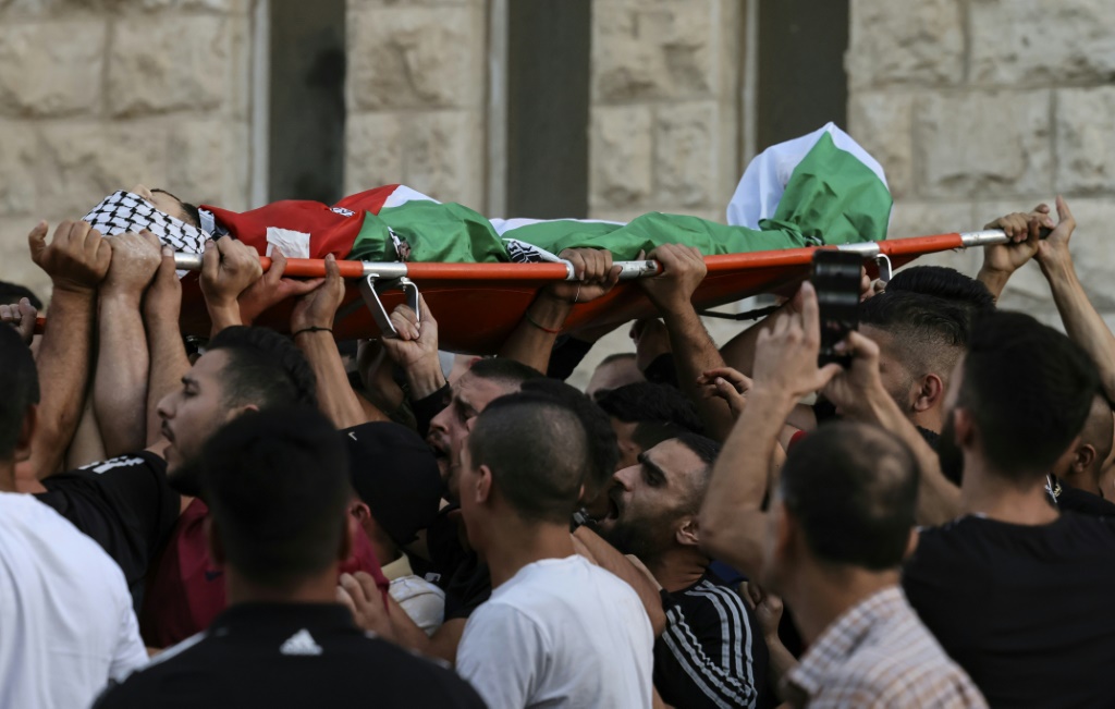 جثمان علاء زغل، 21 عاما، الذي قُتل برصاص الجيش الإسرائيلي في قرية دير الحطب، لدى خروجه من مستشفى في نابلس في 5 تشرين الأول/أكتوبر 2022 (ا ف ب)