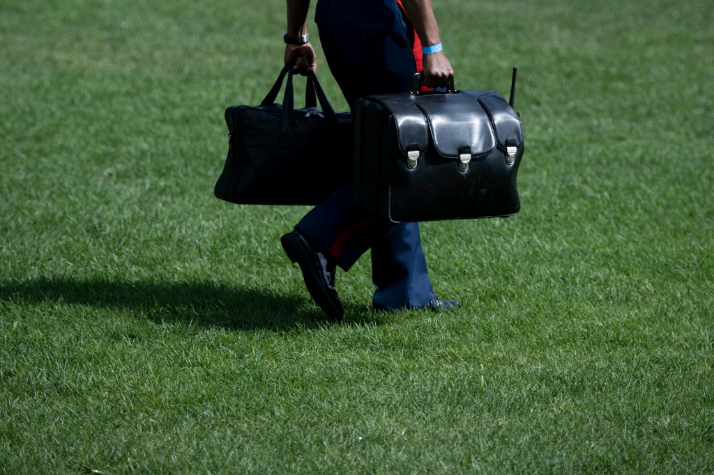 عسكري يحمل "الحقيبة النووية" في حديقة البيت الأبيض لدى مرافقته الرئيس جو بايدن إلى الطائرة مارين وان، في 2 أيلول/سبتمبر 2022 (ا ف ب)
