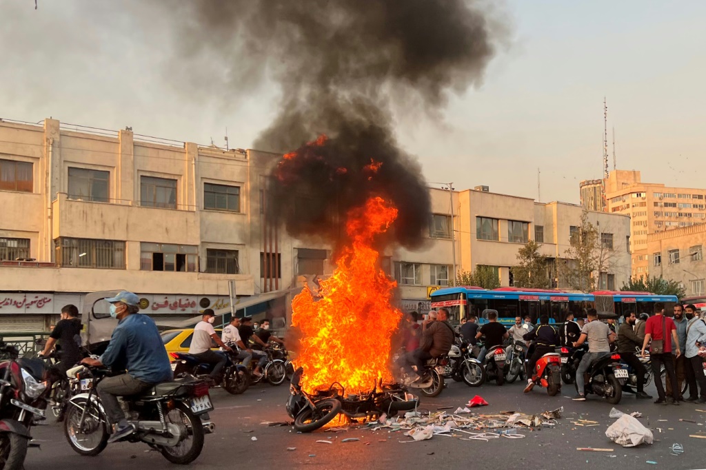  صورة حصلت عليها فرانس برس من خارج إيران تظهر تجمع عدد من الأشخاص ودراجة نارية تحترق في العاصمة طهران في 8 تشرين الأول/أكتوبر 2022 (ا ف ب)  أ