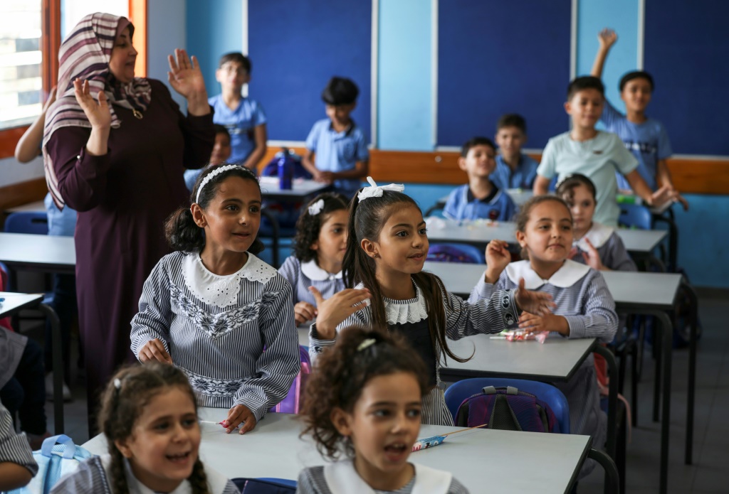 تلاميذ فلسطينيون في أول أيام العام الدراسي في مدرسة تديرها وكالة الأمم المتحدة لإغاثة وتشغيل اللاجئين الفلسطينيين في الشرق الأدنى، في 29 آب/أغسطس في غزة (ا ف ب)