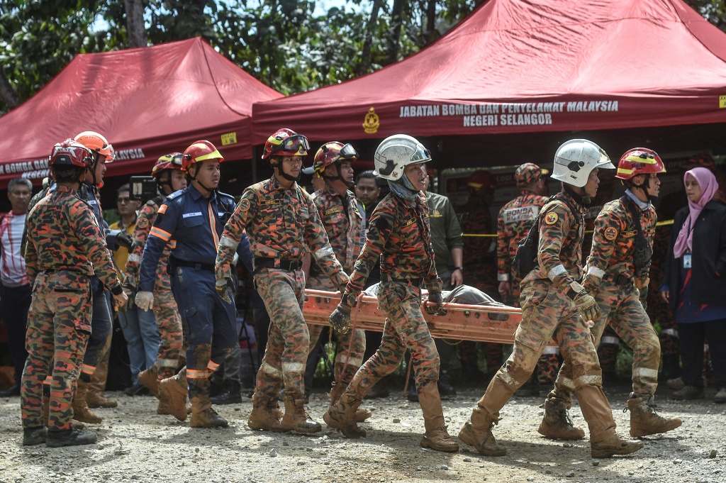 قالت السلطات إنه تم العثور على أكثر من 60 شخصًا في أمان ، بعد الانهيار الأرضي بالقرب من بلدة باتانج كالي ، خارج العاصمة الماليزية كوالالمبور. (ا ف ب)
