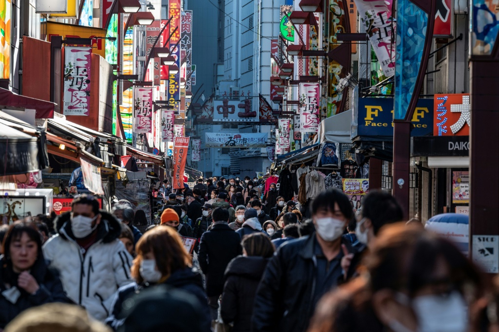 الناس يمشون بالقرب من المتاجر في منطقة التسوّق الشهيرة أوينو في طوكيو في 23 كانون الأول/ديسمبر 2022 (ا ف ب)