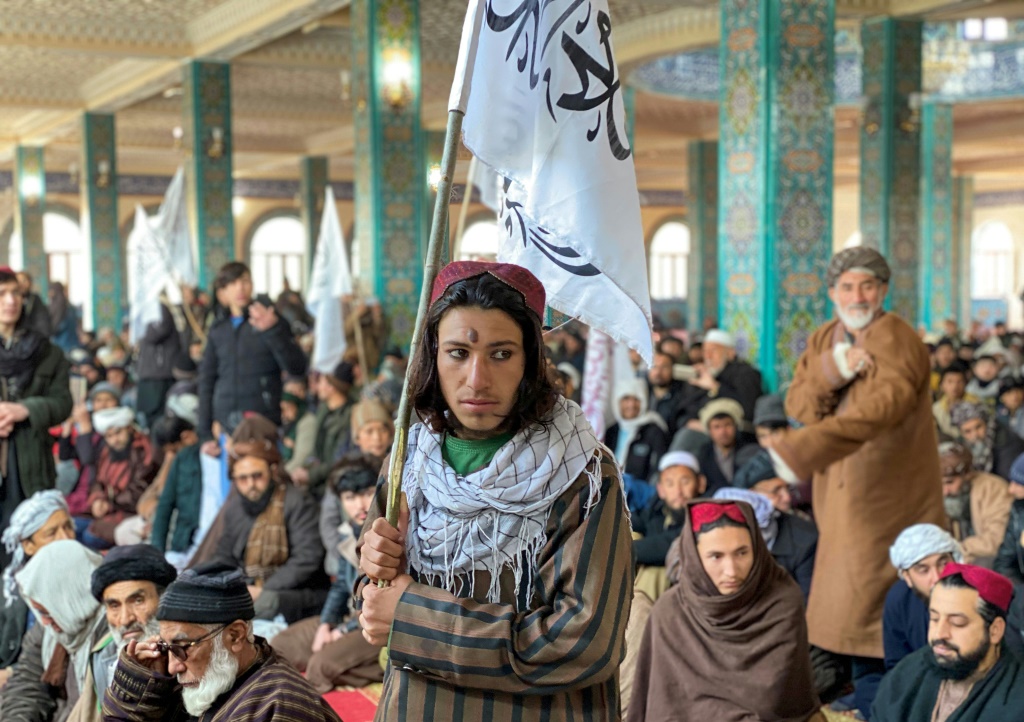   رجل أفغاني يحمل علم طالبان خلال مظاهرة في مزار الشريف. وخرجت احتجاجات في أفغانستان وباكستان ضد إحراق أحد السياسيين للقرآن الكريم في السويد (ا ف ب)