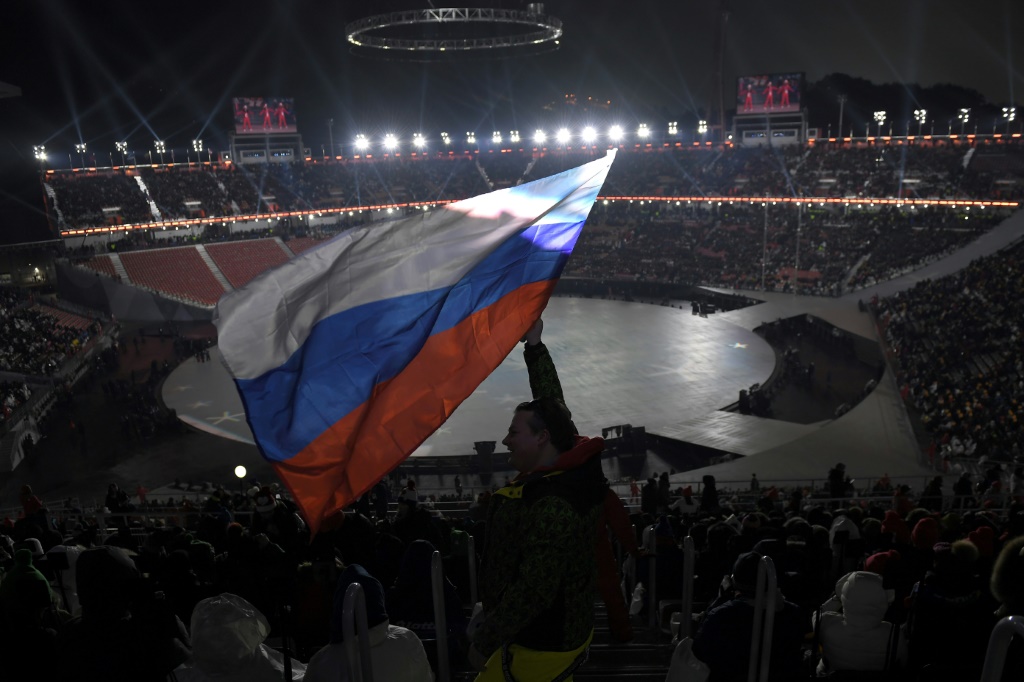 مشجّع يلوح بالعلم الروسي قبل حفل افتتاح دورة الألعاب الأولمبية الشتوية في بيونغ تشانغ 2018 (ا ف ب)