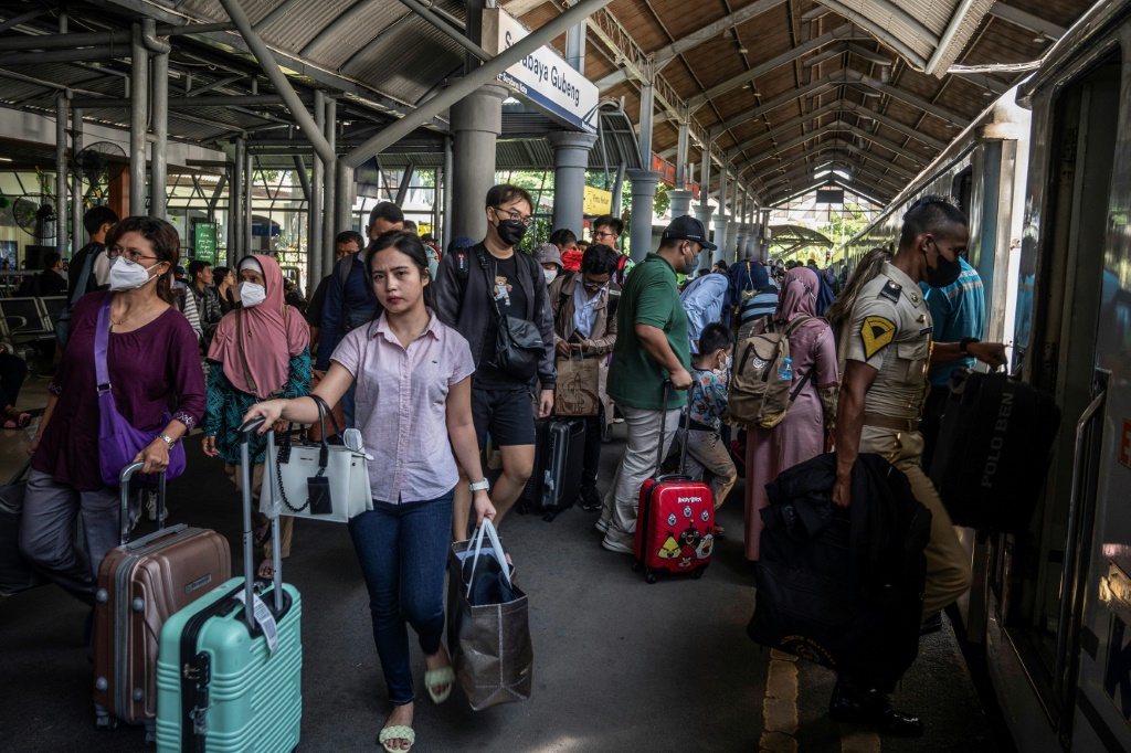ركاب يستقلون قطارًا في سورابايا بينما يقوم ملايين الإندونيسيين بخروج "الموديك" السنوي إلى الوطن لقضاء عطلة عيد الفطر في نهاية شهر رمضان المبارك (أ ف ب)