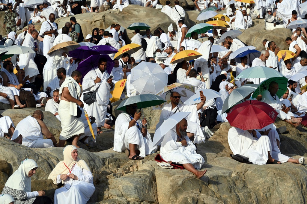 حجاج يصلون ويدعون على جبل الرحمة في منطقة عرفات خلال ذروة مناسك الحج في 27 حزيران/يونيو 2023 (أ ف ب)   