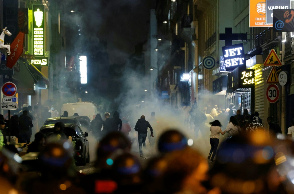 متظاهرون يفرون من الغاز المسيل للدموع الذي اطلقته الشرطة الفرنسية في باريس في 2 تموز/يوليو 2023 بعد خمسة أيام على مقر شاب برصاص الشرطة في ضاحية نانتير (ا ف ب)