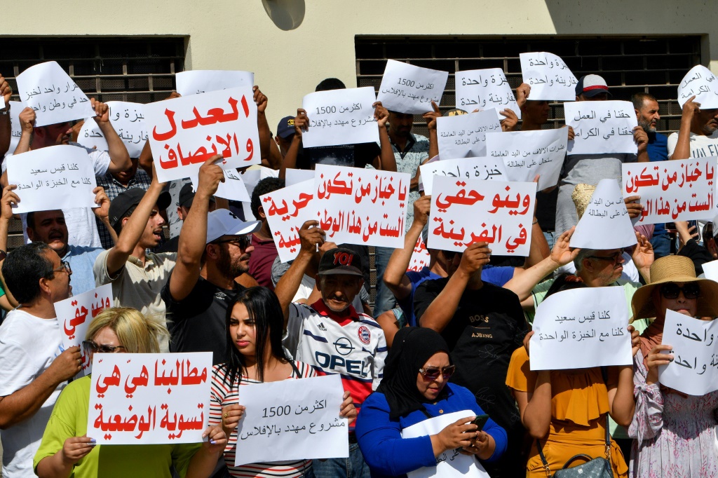 متظاهرون يرفعون لافتات خلال مسيرة للعاملين في المخابز أمام مقر وزارة التجارة في تونس العاصمة في 7 آب/أغسطس 2023 عقب قرارها بوقف حصول بعض المخابز على الدقيق المدعوم (أ ف ب)   
