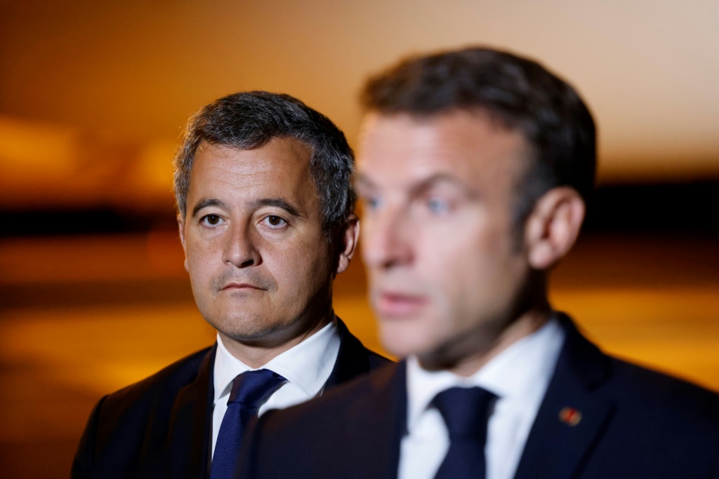 وزير الداخلية الفرنسي جيرالد دارمانان يقف خلف الرئيس إيمانويل ماكرون في 24 تموز/يوليو 2023 (ا ف ب)