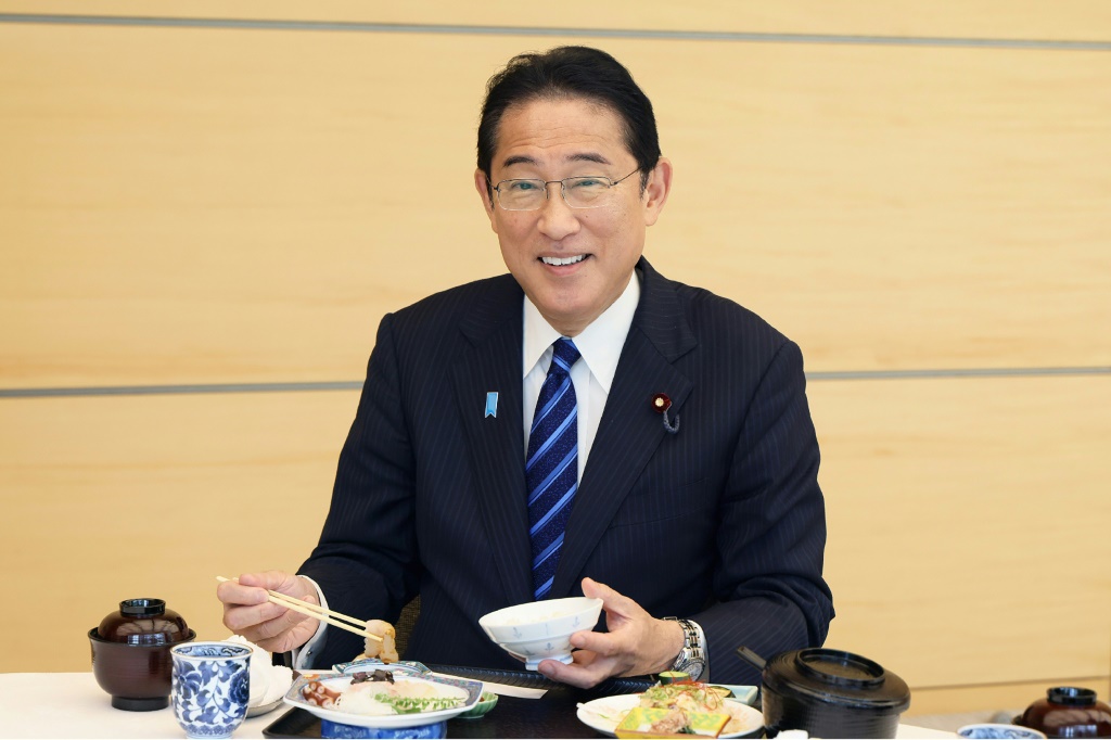 صورة مؤرخة في 30 آب/أغسطس 2023 لرئيس الوزراء الياباني فوميو كيشيدا يتناول السمك من فوكوشيما في مكتبه في طوكيو (ا ف ب)