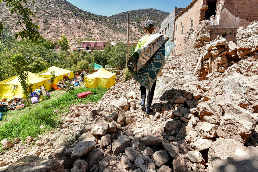 شاب يسير وسط ركام قريته انغيد التي ضربها الزلزال في إقليم الحوز في المغرب بتاريخ 13 أيلول/سبتمبر 2023 (أ ف ب)   