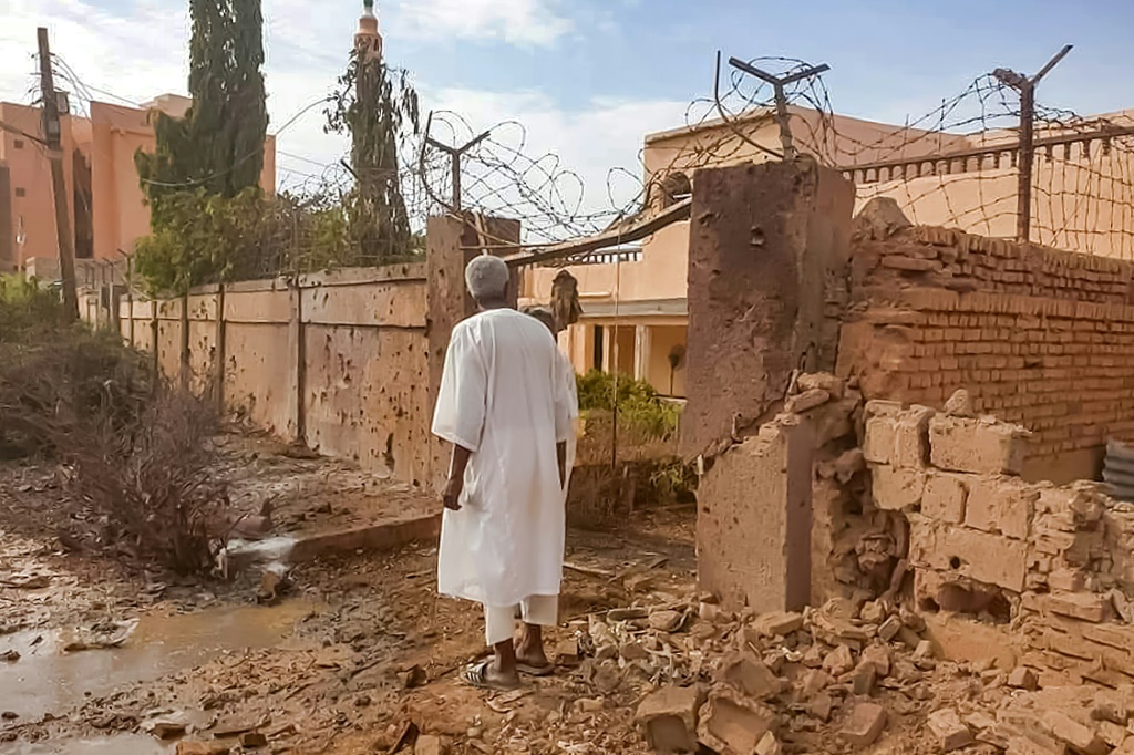   رجل سوداني يتفقد أضرار المعارك في ضاحية أم درمان في الخرطوم في الرابع من تموز/يوليو 2023 (أ ف ب)