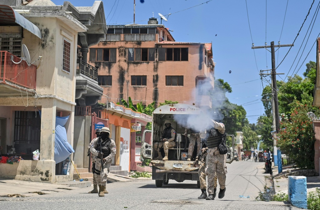 شرطي يطلق الغاز المسيل للدموع فيما يتظاهر عدد من الاشخاص احتجاجا على ارتفاع كلفة المعيشة في بوتي غواف بهايتي، في 14 أيلول/سبتمبر 2023 (ا ف ب)