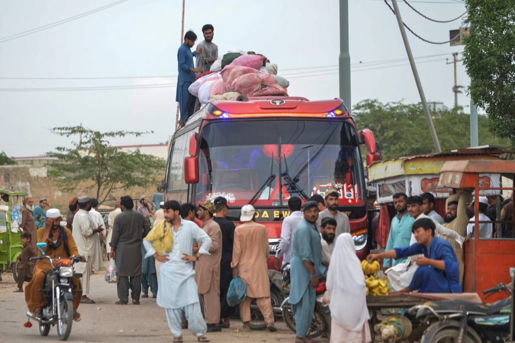 أفغان يستقلون حافلة كانت من المفترض أن تعيدهم إلى ديارهم في مدينة كراتشي الساحلية الباكستانية في أواخر سبتمبر (أ ف ب)   