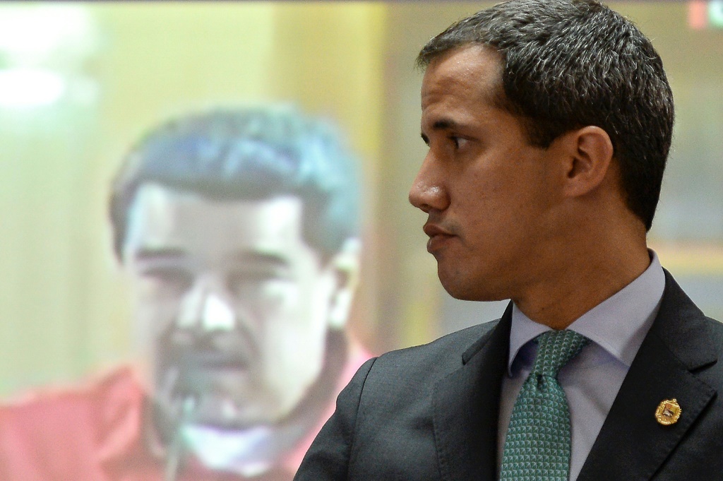 المعارض الفنزويلي خوان غوايدو أمام شاشة عليها صورة الرئيس نيكولاس مادورو، في كراكاس في 3 أيلول/سبتمبر 2019 (ا ف ب)