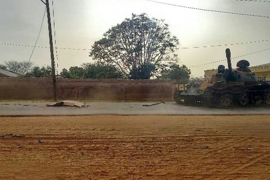 صورة تم التقاطها في 16 حزيران/يونيو 2023 تظهر جثة مغطاة قبالة دبابة عسكرية في أحد شوارع الجنينة، عاصمة ولاية غرب دارفور، وسط القتال المستمر في السودان بين قوات الدعم السريع والجيش (ا ف ب)