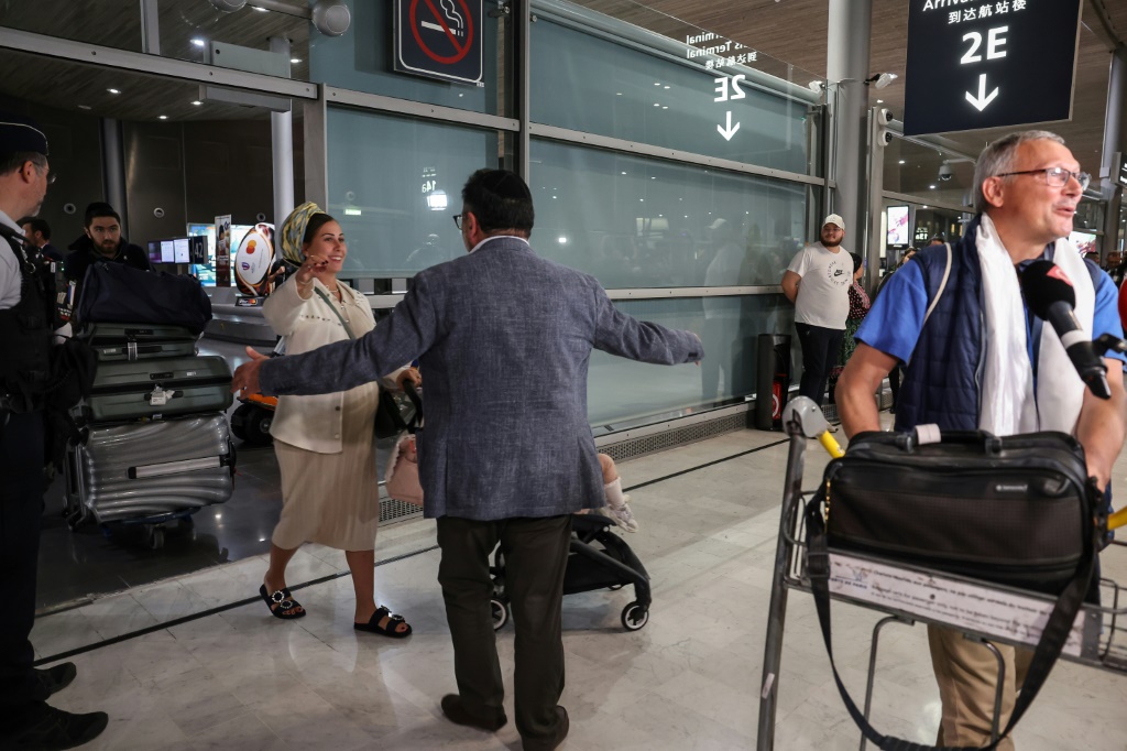 مسافرون وافدون من تل أبيب إلى مطار رواسي شارل ديغول بضواحي باريس على متن أول رحلة خاصة منذ بدء هجوم حركة حماس على إسرائيل في 12 تشرين الأول/أكتوبر 2023 (ا ف ب)