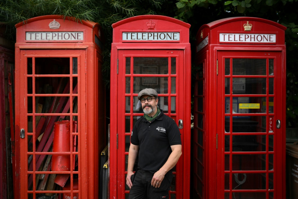 كارل بيرج أمام أكشاك هاتف حمراء تقليدية في منطقة كينغز لين في شرق إنكلترا في 11 آب/أغسطس 2023 (ا ف ب)
