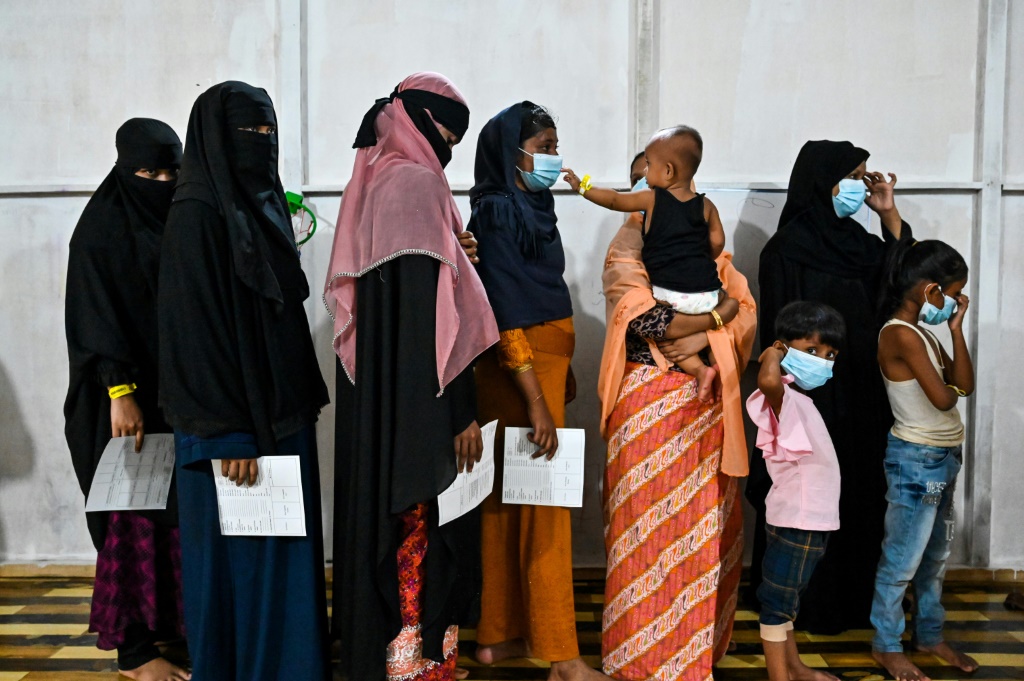 لاجئون من الروهينجا يصطفون في طابور للتحقق من هوياتهم في مأوى مؤقت في مقاطعة آتشيه بإندونيسيا (أ ف ب)   