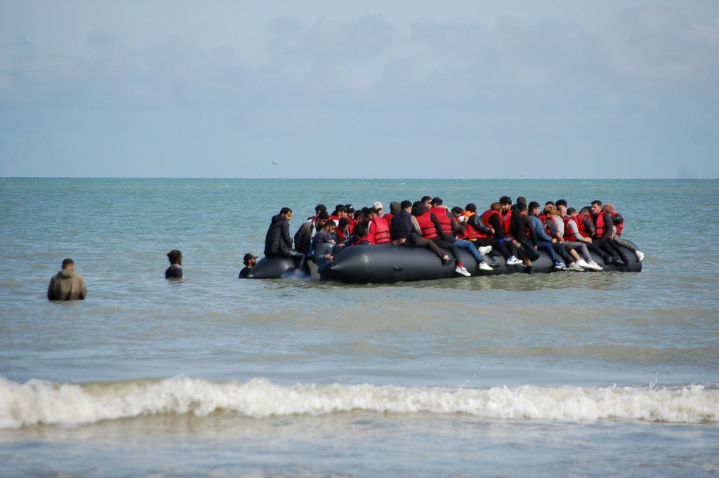 مهاجرون على متن قارب مطاطي قبل محاولتهم عبور المانش إلى بريطانيا من شمال فرنسا بتاريخ 18 تموز/يوليو 2023 (ا ف ب)
