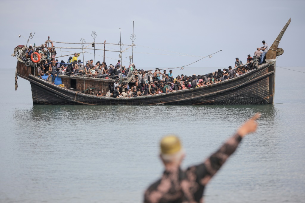 تم إبعاد المئات من اللاجئين الروهينجا اليائسين الذين كانوا على متن قارب خشبي مكتظ عن غرب إندونيسيا، وأجبرهم السكان المحليون على العودة إلى البحر. (أ ف ب)   