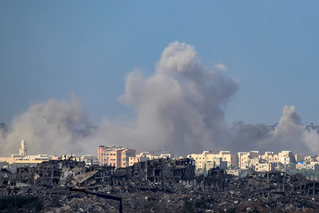 الدخان يتصاعد فوق المباني المدمرة في الأراضي الفلسطينية في 20 نوفمبر 2023، وسط المعارك المستمرة بين إسرائيل وحركة حماس الفلسطينية (أ ف ب)