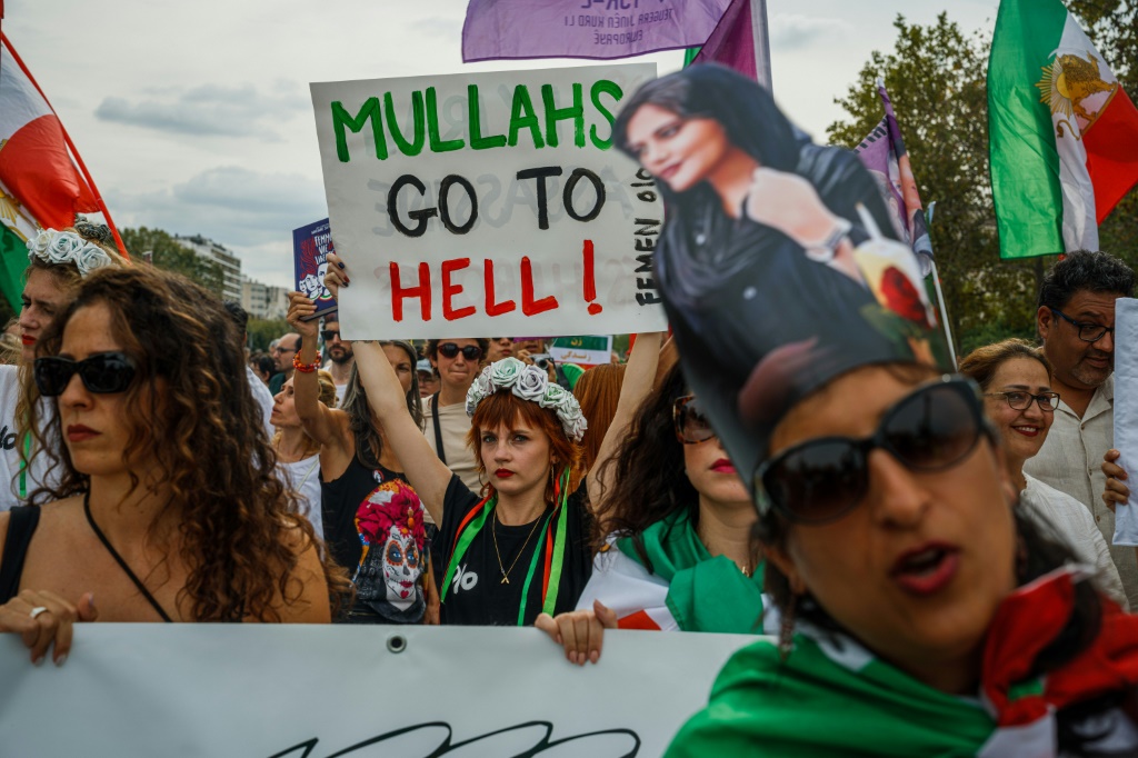 متظاهرة تحمل لافتة خلال تظاهرة مناهضة للجمهورية الإسلامية في إيران في باريس في 16 أيلول/سبتمبر في الذكرى الأولى لوفاة الشابة مهسا أميني (أ ف ب)   