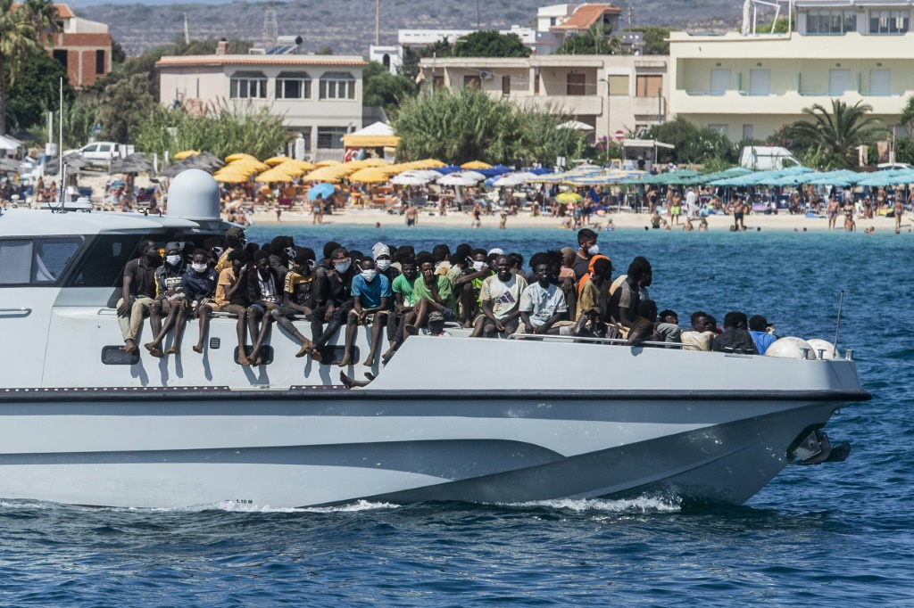 مهاجرون على متن قارب تابع للشرطة الإيطالية لدى وصوله الى ميناء جزيرة لامبيدوسا في 15 أيلول/سبتمبر 2023 (ا ف ب)