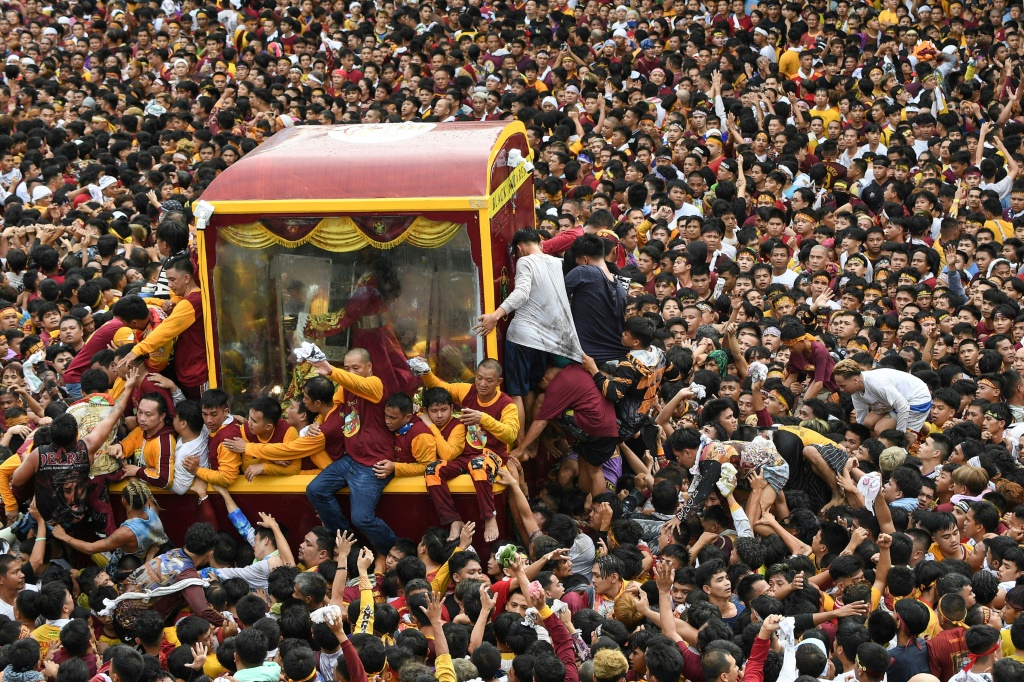 اجتاح مئات الآلاف من المؤمنين الكاثوليك تمثالاً تاريخياً ليسوع المسيح أثناء سحبه في شوارع العاصمة الفلبينية. (ا ف ب)