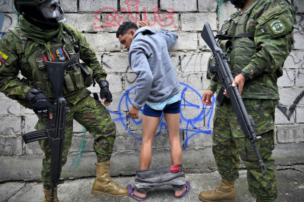 جنود يفتشون رجلاً أثناء دورية في العاصمة الإكوادورية كيتو في 12 يناير 2024. (ا ف ب)