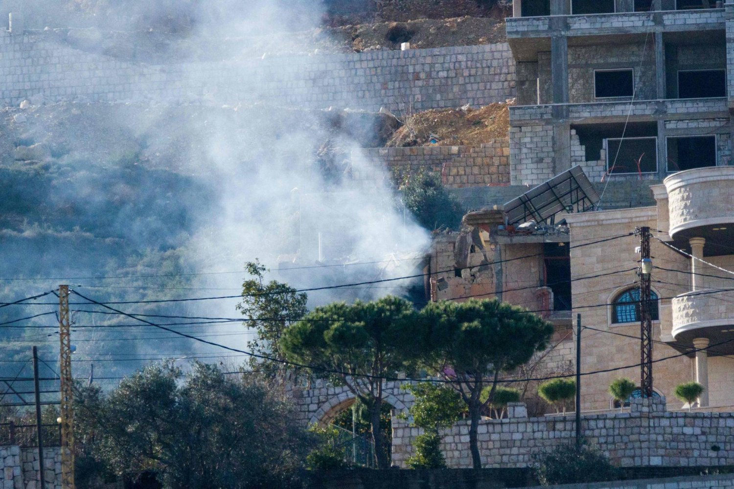 دخان غارة إسرائيلية يتصاعد من منزل دُمّر بالكامل في بلدة كفركلا الحدودية بجنوب لبنان (أ.ف.ب)