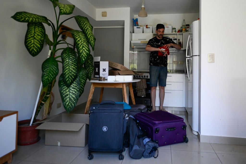الشاب الأرجنتيني توماس سيسليان (28 عامًا) يوضّب أغراضه استعدادًا لترك شقته المستأجرة في بوينوس آيرس بسبب أزمة في قطاع العقارات، في الثامن من كانون الثاني/يناير 2024 (أ ف ب)   