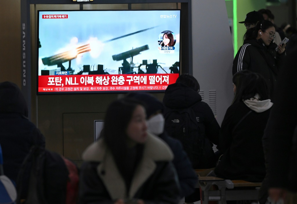 أشخاص يشاهدون تلفازًا يعرض نشرة إخبارية تبث لقطات من إطلاق نار كوري شمالي في السادس من كانون الثاني/يناير 2024 (ا ف ب)