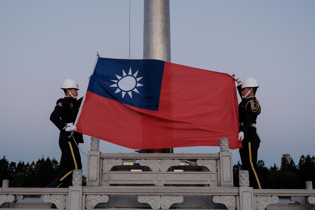 عنصران يرفعان علم تايوان في تايبيه في 14 كانون الثاني/يناير 2024 (ا ف ب)