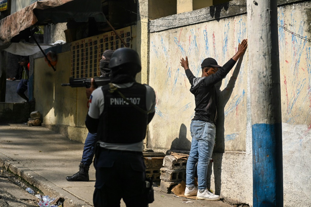 الشرطة الهايتية تعتقل رجلاً في بلدية تورجو في بورت أو برنس خلال أعمال عنف مرتبطة بالعصابات في أبريل 2023. (ا ف ب)