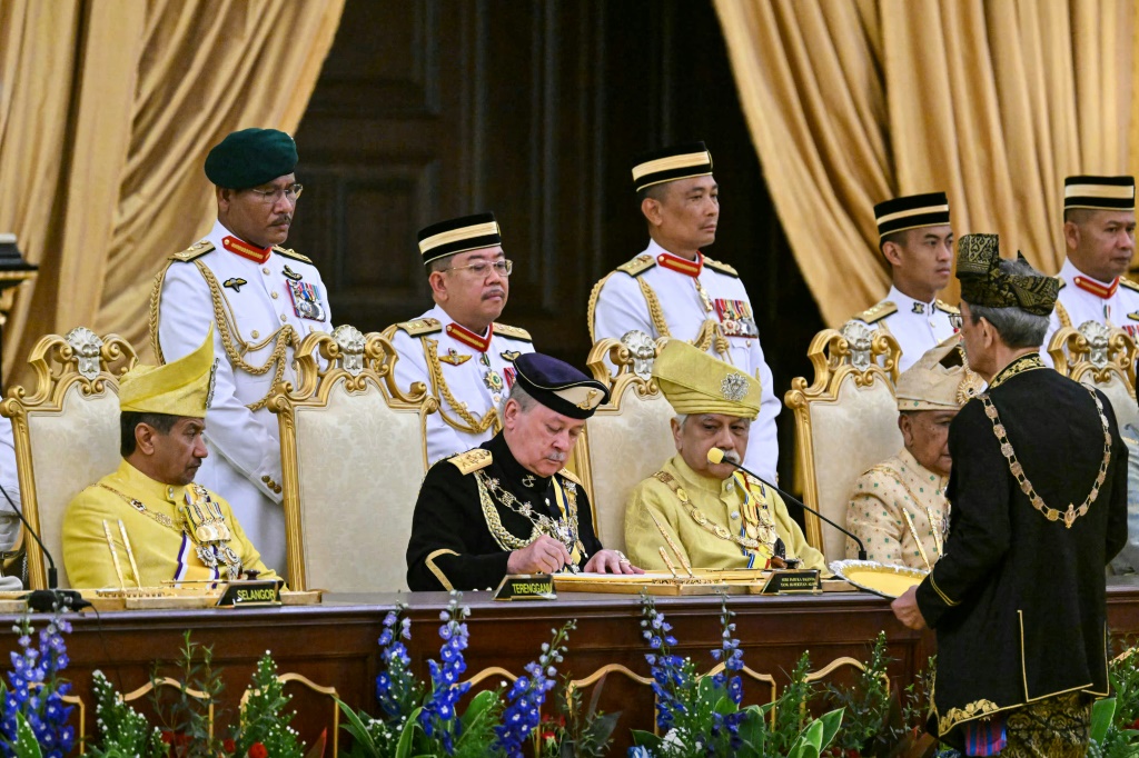 السلطان إبراهيم اسكندر (في الوسط) يوقع الوثائق خلال مراسم أداء القسم يوم الأربعاء في القصر الوطني بماليزيا.(ا ف ب)