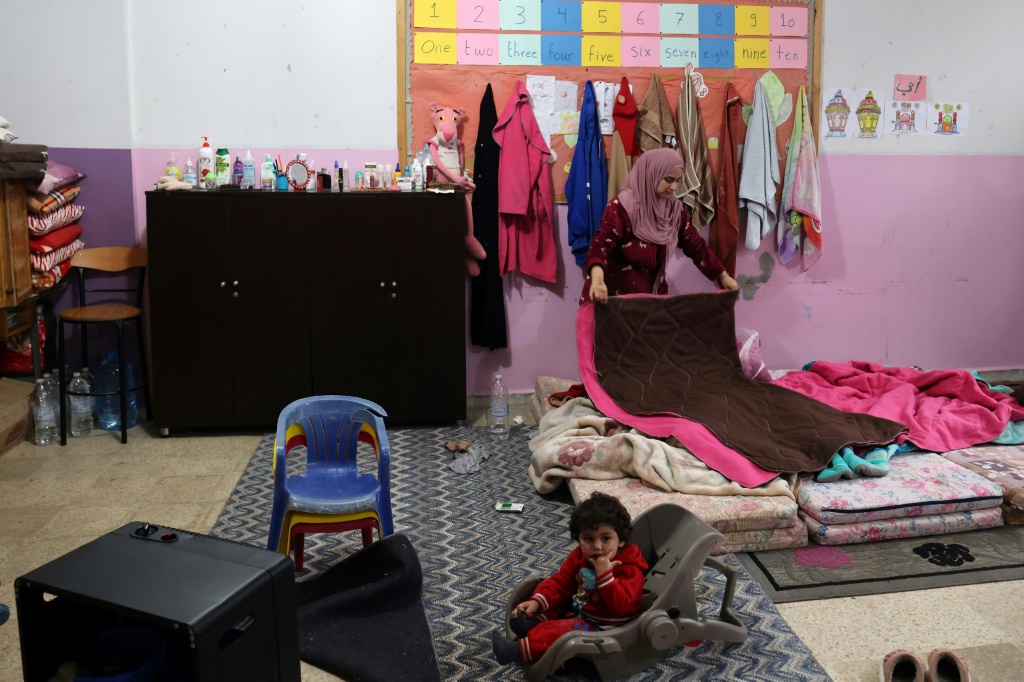 اللبنانية إيناس طحيني التي فرت مع عائلتها من بلدة في جنوب لبنان، توضب الغرفة التي تقيم فيها بمدرسة في مدينة صور في 31 كانون الثاني/يناير 2024 (ا ف ب)