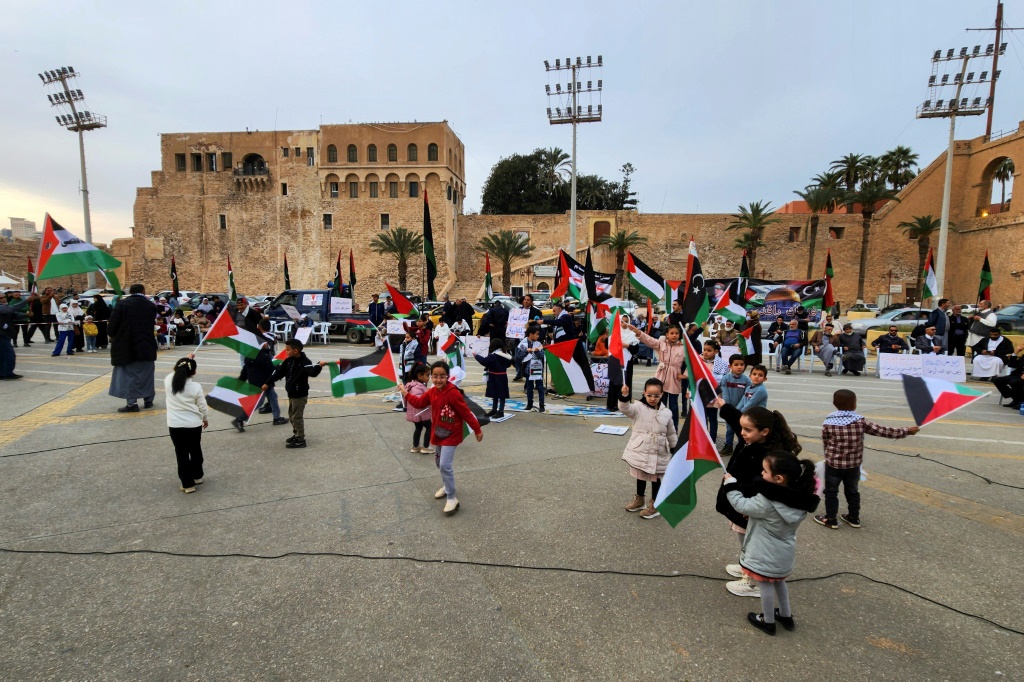    صورة مؤرخة في 19 كانون الثاني/يناير 2024 لليبيين يحملون أعلاما ليبيبة وفلسطينية في ساحة الشهداء في طرابلس (أ ف ب)   